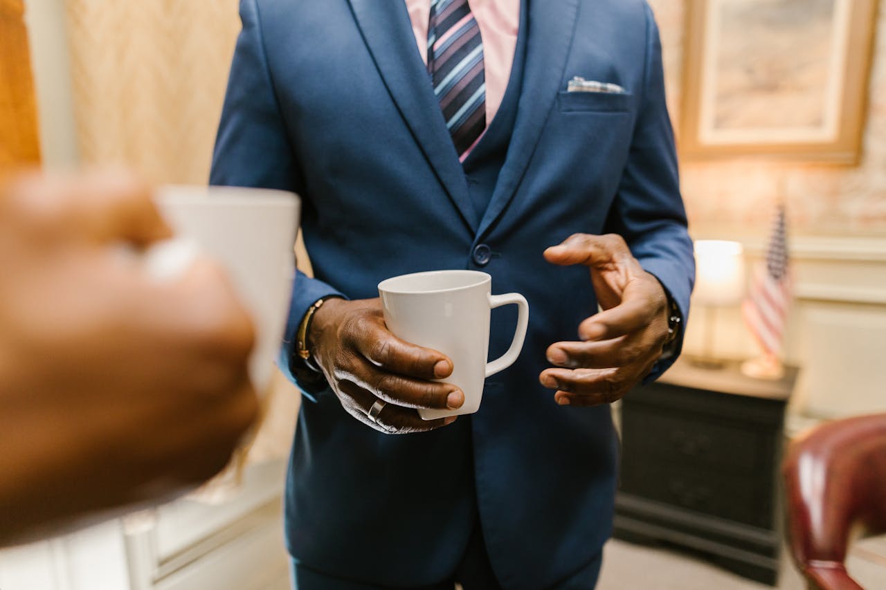 Two professionals engaging in conversation over coffee during a business meeting.